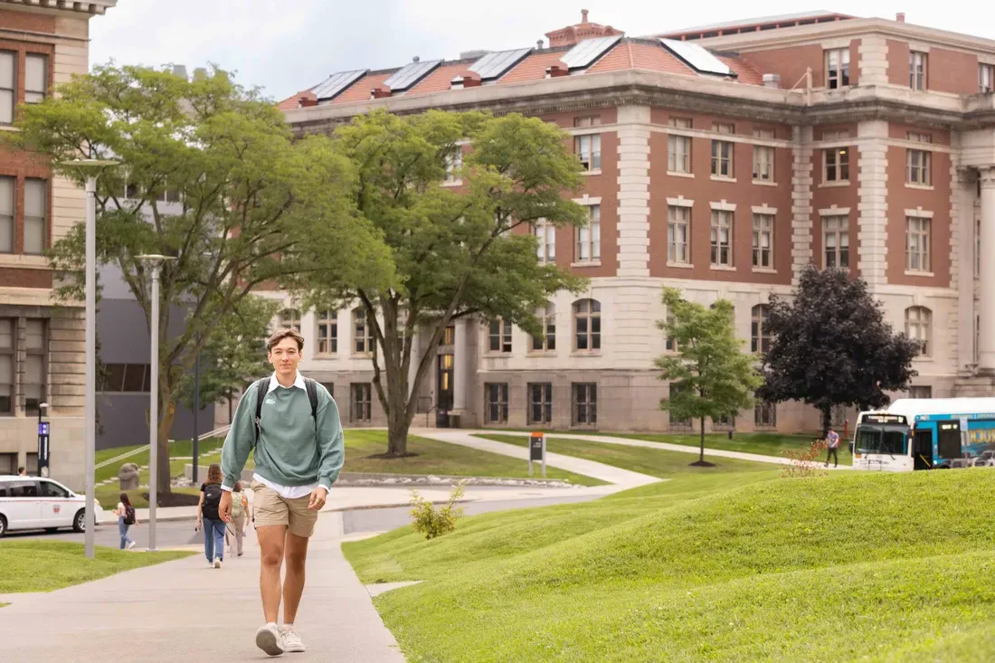 Student walking by ernie davis dorms.